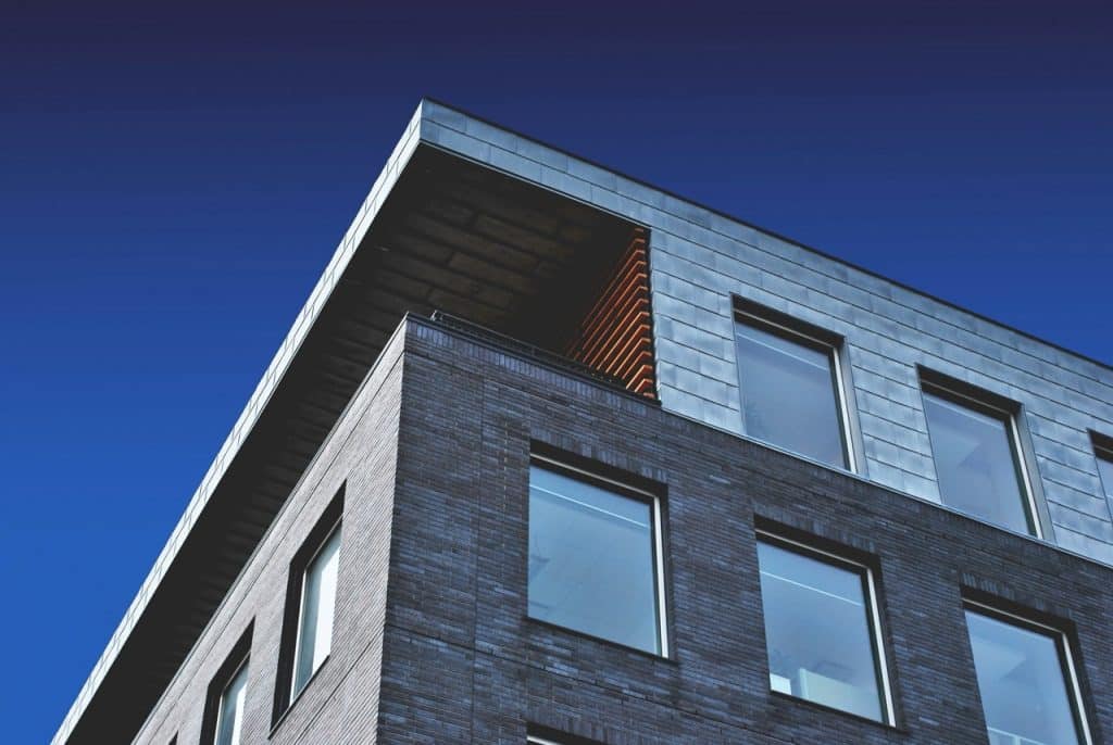 Moderne Gebäudeecke mit großen Fenstern vor blauem Himmel